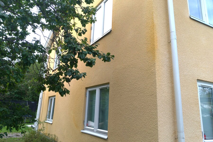Gultonad ädelputsad fasad på villa efter fasadrenovering.